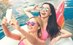 Two women on a pool toy taking a selfie